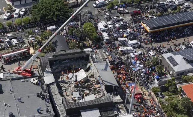 Rescue workers search for survivors at the Jet Set nightclub after its roof collapsed during a merengue concert in Santo Domingo, Dominican Republic, Tuesday, April 8, 2025. (AP Photo/Eddy Vittini)