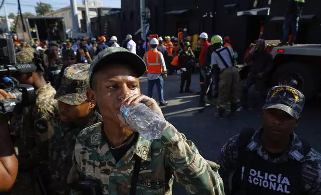 A soldier hydrates while rescue workers search for survivors at the Jet Set nightclub after its roof collapsed during a merengue concert in Santo Domingo, Dominican Republic, Tuesday, April 8, 2025. (AP Photo/Eddy Vittini)