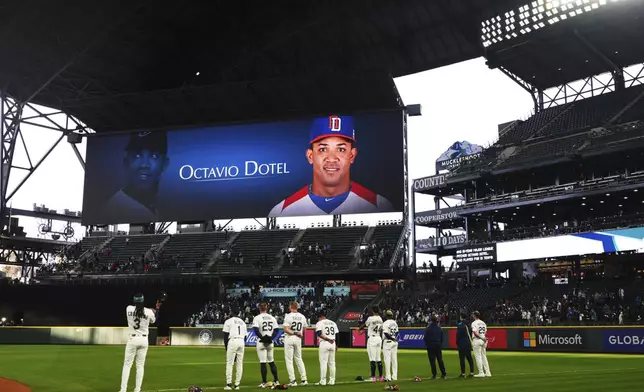 Members of the Seattle Mariners stand during a moment of silence for Octavio Dotel, a former MLB player who died in a roof collapse at a nightclub in the Dominican Republic, before a baseball game between the Mariners and the Houston Astros, Tuesday, April 8, 2025, in Seattle. (AP Photo/Lindsey Wasson)