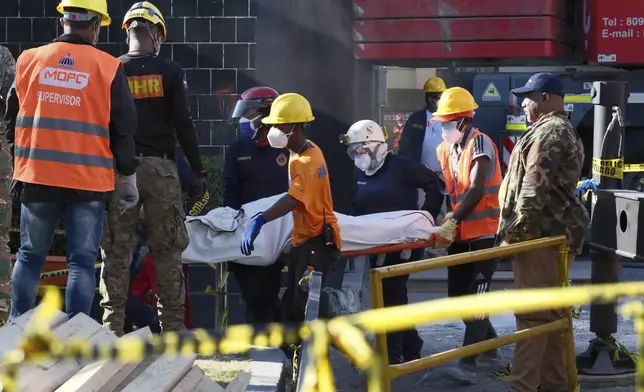 Rescue workers recover the body of a victim who died when the roof collapsed two nights prior at the Jet Set nightclub during a merengue concert, in Santo Domingo, Dominican Republic, Wednesday, April 9, 2025, (AP Photo/Marvin Del Cid)