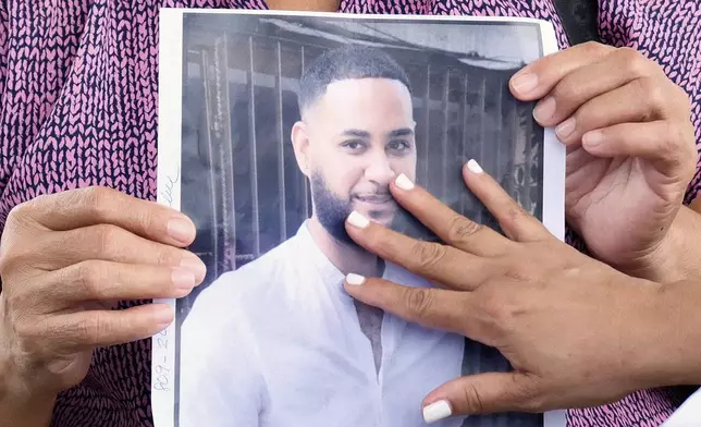 A woman touches a photo of one of the missing during the search for survivors at the Jet Set nightclub after its roof collapsed two nights prior during a merengue concert in Santo Domingo, Dominican Republic, Wednesday, April 9, 2025. (AP Photo/Ricardo Hernandez)