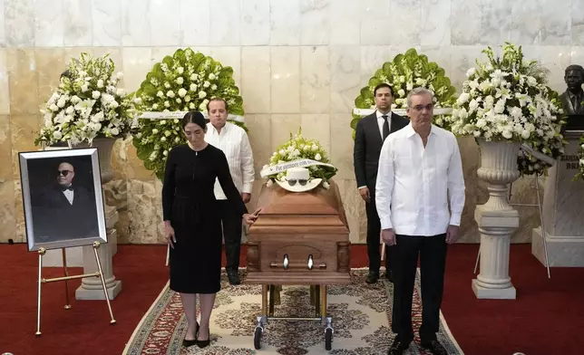 Dominican Republic President Luis Abinader, front right ands his wife Raquel Arbaje Soni, front left, attend the wake of Dominican singer Rubby Perez who died in the roof collapse at the Jet Set nightclub during his merengue concert, at the Eduardo Brito National Theater in Santo Domingo, Dominican Republic, Thursday, April 10, 2025. (AP Photo/Matias Delacroix)