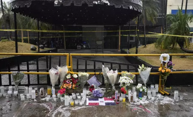 Flowers and candles sit outside the Jet Set nightclub, placed in memory of the more than 200 people who died when its roof collapsed in Santo Domingo, Dominican Republic, Friday, April 11, 2025. (AP Photo/Matias Delacroix)