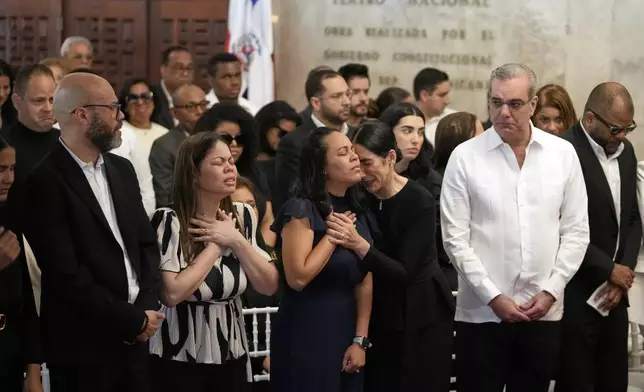 Dominican Republic President Luis Abinader, second from right, and his wife Raquel Arbaje Soni, third from right, attends the wake of Dominican singer Rubby Perez who died in the roof collapse at the Jet Set nightclub during his merengue concert, at the Eduardo Brito National Theater in Santo Domingo, Dominican Republic, Thursday, April 10, 2025. (AP Photo/Matias Delacroix)