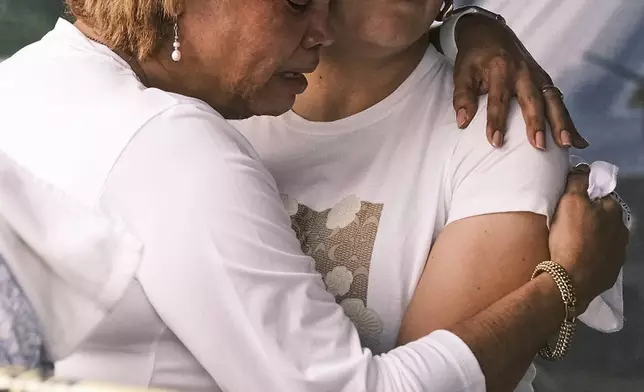 People hug and cry during the search for survivors at the Jet Set nightclub after its roof collapsed two nights prior during a merengue concert in Santo Domingo, Dominican Republic, Wednesday, April 9, 2025. (AP Photo/Ricardo Hernandez)