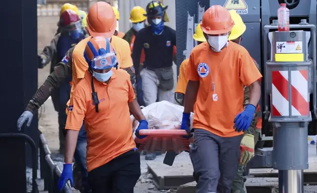 Rescue workers carry the recovered body of a victim who died when the roof collapsed two nights prior at the Jet Set nightclub during a merengue concert, in Santo Domingo, Dominican Republic, Wednesday, April 9, 2025, (AP Photo/Ricardo Hernandez)
