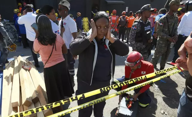 A woman stands outside the Jet Set nightclub after its roof collapsed during a merengue concert in Santo Domingo, Dominican Republic, Tuesday, April 8, 2025. (AP Photo/Ricardo Hernandez)