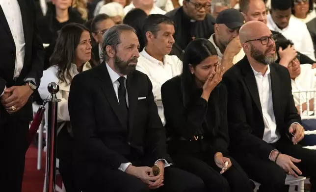 Dominican singer Juan Luis Guerra, left, attends a wake of Rubby Perez, the merengue singer who was performing at the Jet Set nightclub when its roof collapsed, killing more than 200 people, at the National Theater in Santo Domingo, Dominican Republic, Thursday, April 10, 2025. (AP Photo/Matias Delacroix)