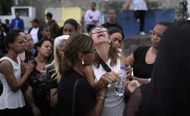 Family and friends grieve during the burial service for Marilenny Pilarte who died at the Jet Set nightclub when its roof collapsed, in Haina, Dominican Republic, Thursday, April 10, 2025. (AP Photo/Matias Delacroix)
