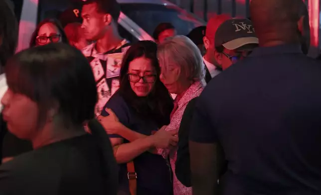 Relatives of missing people embrace while waiting at the National Institute of Forensic Pathology after the roof collapsed at Jet Set nightclub during a merengue concert in Santo Domingo, Dominican Republic, Tuesday, April 8, 2025. (AP Photo/Ricardo Hernandez)