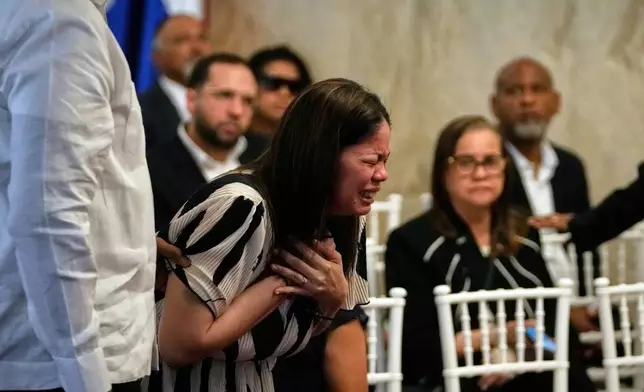 Zulinka, center, the daughter of Dominican singer Rubby Perez who died in the roof collapse at the Jet Set nightclub during his merengue concert, cries during his wake at the Eduardo Brito National Theater in Santo Domingo, Dominican Republic, Thursday, April 10, 2025. (AP Photo/Matias Delacroix)
