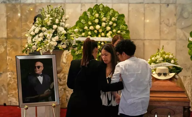 Zulinka, center, daughter of Dominican singer Rubby Perez, who died in the roof collapse at the Jet Set nightclub during his merengue concert, attends his wake at the Eduardo Brito National Theater in Santo Domingo, Dominican Republic, Thursday, April 10, 2025. (AP Photo/Matias Delacroix)