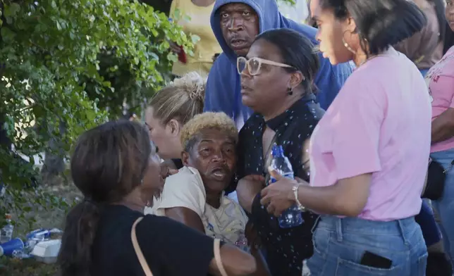 A relative of a missing person is comforted by friends outside Jet Set nightclub after its roof collapsed during a merengue concert in Santo Domingo, Dominican Republic, Tuesday, April 8, 2025. (AP Photo/Ricardo Hernandez)