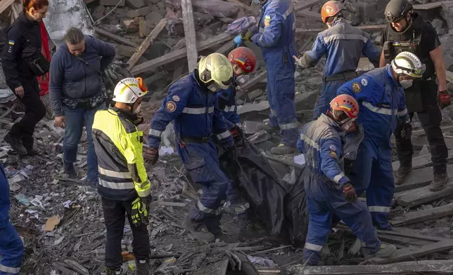 Rescue workers carry the body of a victim found under the rubble after a Russian strike in a residential neighborhood in Kyiv, Ukraine, Thursday, April 24, 2025. (AP Photo/Alex Babenko)