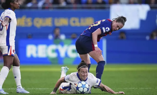 Chelsea's Lucy Bronze falls to the ground next to Barcelona's Ewa Pajor during the women's Champions League semifinals, first leg, soccer match between FC Barcelona and Chelsea FC at the Johan Cruyff Stadium, in Sant Joan Despi, outside Barcelona, Spain, Sunday, April 20, 2025. (AP Photo/Bagu Blanco)
