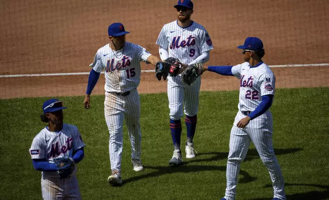 New York Mets players congratulate each other on a zero-run fourth inning for the St. Louis Cardinals during a baseball game, Sunday, April 20, 2025, in New York. (AP Photo/Angelina Katsanis)