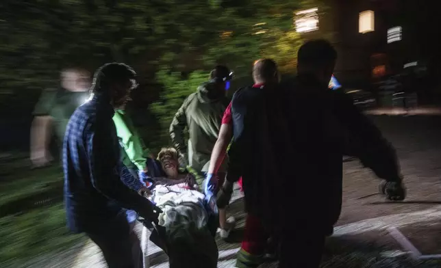 Rescue workers carry an injured woman on a stretcher out of a house destroyed by a Russian airstrike in a residential neighbourhood in Kyiv, Ukraine, on Thursday, April 24, 2025. (AP Photo/Evgeniy Maloletka)