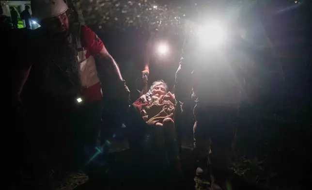 Rescue workers transport a woman on a makeshift stretcher outside of a house destroyed by a Russian airstrike in a residential neighborhood in Kyiv, Ukraine, on Thursday, April 24, 2025. (AP Photo/Evgeniy Maloletka)