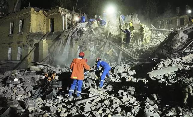 Ukrainian searchers clear the rubble after a Russian ballistic missile attack in Kyiv, Ukraine, early Thursday, April 24, 2025. (AP Photo/Efrem Lukatsky)