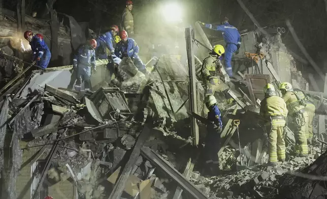 Ukrainian searchers clear the rubble after a Russian ballistic missile attack in Kyiv, Ukraine, early Thursday, April 24, 2025. (AP Photo/Efrem Lukatsky)