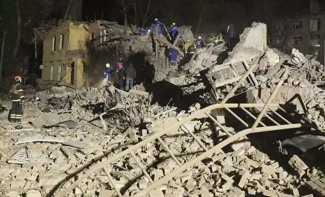 Ukrainian searchers clear the rubble after a Russian ballistic missile attack in Kyiv, Ukraine, early Thursday, April 24, 2025. (AP Photo/Efrem Lukatsky)