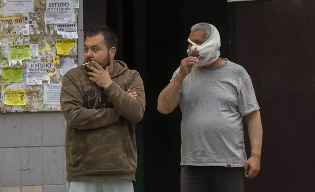 Injured victims stand and smoke after a Russian airstrike in a residential neighborhood in Kyiv, Ukraine, Thursday, April 24, 2025. (AP Photo/Alex Babenko)