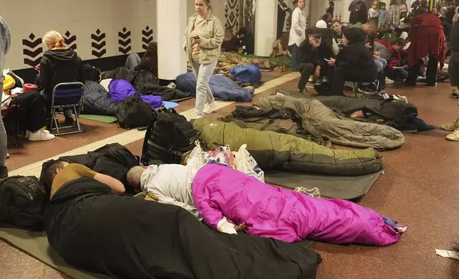 People rest in a metro station, being used as a bomb shelter, during a Russian missile attack in Kyiv, Ukraine, early Thursday, April 24, 2025. (AP Photo/Efrem Lukatsky)