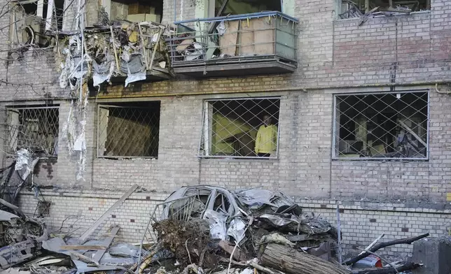 A man looks out from an apartment building damaged after a Russian ballistic missile attack in Kyiv, Ukraine, Thursday, April 24, 2025. (AP Photo/Efrem Lukatsky)