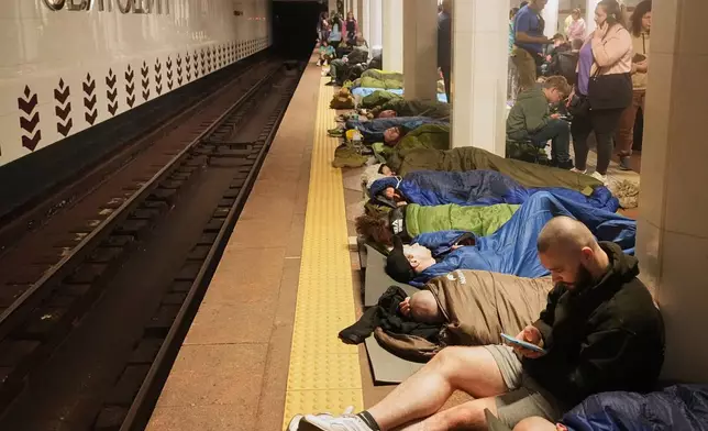 People rest in a metro station, being used as a bomb shelter, during a Russian missile attack in Kyiv, Ukraine, early Thursday, April 24, 2025. (AP Photo/Efrem Lukatsky)