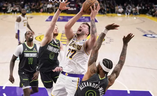 Los Angeles Lakers guard Luka Doncic (77) shoots as Minnesota Timberwolves guard Nickeil Alexander-Walker (9), guard Donte DiVincenzo (0) and center Naz Reid (11) defend during the second half in Game 1 of an NBA first-round playoff series Saturday, April 19, 2025, in Los Angeles. (AP Photo/Mark J. Terrill)