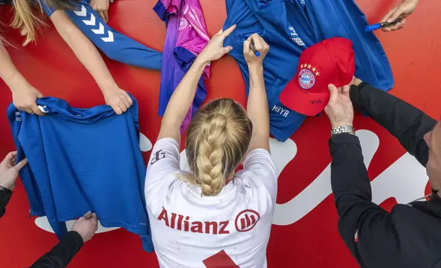 Giulia Gwinn from Bayern Munich signs autographs for the waiting fans after the end of the match and after winning the championship title against SC Freiburg in Munich, Germany, Sunday, April 27, 2025. (Peter Kneffel/dpa via AP)