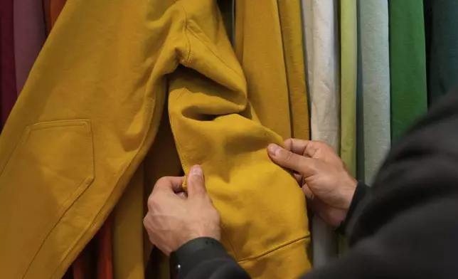 Javid Moghaddasnia, Director of Customer Engagement, holds the sleeve to an American Giant hoodie while being interviewed at the company's showroom in San Francisco, Thursday, April 17, 2025. (AP Photo/Jeff Chiu)
