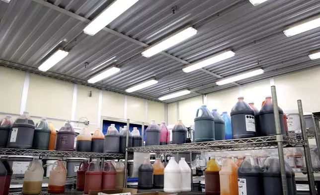 Liquid color samples are stored in bottles in a room at Sensient Technologies Corp., a color additive manufacturing company, in St. Louis, on Wednesday, April 2, 2025. (AP Photo/Jeff Roberson)