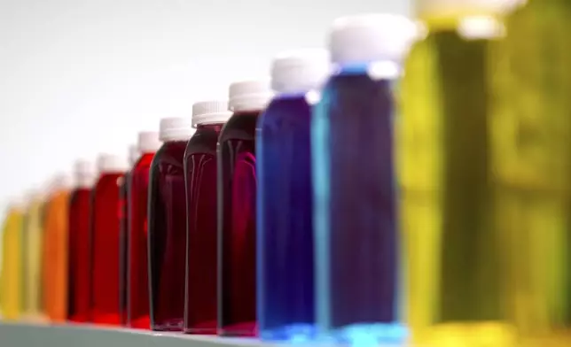 Bottles containing a variety of colored liquids sit on a shelf in a lab at Sensient Technologies Corp., a color additive manufacturing company, in St. Louis., on Wednesday, April 2, 2025. (AP Photo/Jeff Roberson)
