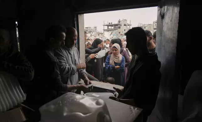 Palestinians receive humanitarian aid distributed by UNRWA, the U.N. agency helping Palestinian refugees in Jabaliya, Gaza Strip on Wednesday, April 9, 2025. (AP Photo/Jehad Alshrafi)