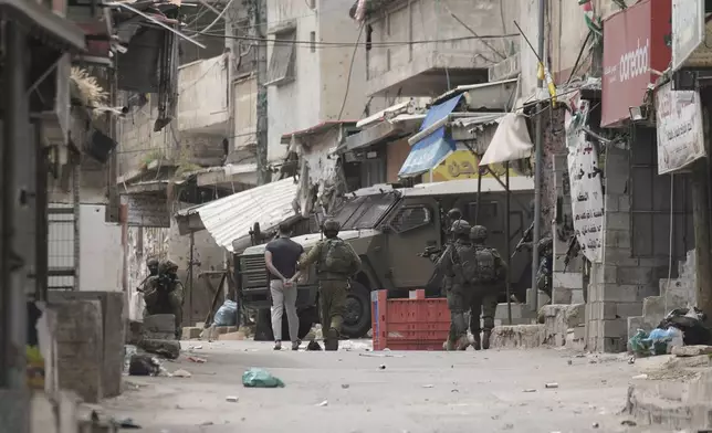 Israeli soldiers arrest a Palestinian man during an army raid in the West Bank refugee camp of Balata, on Wednesday, April 9, 2025. (AP Photo/Majdi Mohammed)
