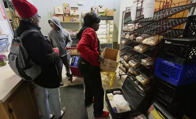 People collect food staples at the Bishop Sullivan Center food pantry, Tuesday, April 15, 2025, in Kansas City, Mo. (AP Photo/Charlie Riedel)