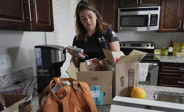 Shea Giagnorio packs belongings in her apartment days after getting fired from her job with the Administration for Children and Families, Monday, April 14, 2025, in Overland Park, Kan. (AP Photo/Charlie Riedel)