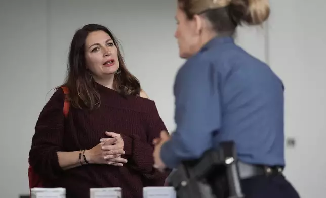 Shea Giagnorio, left, talks to a recruiter at a job fair on the day she was laid off from her job at the Administration for Children and Families, Tuesday, April 1, 2025, in Kansas City, Mo. (AP Photo/Charlie Riedel)