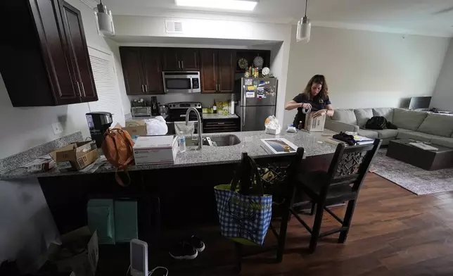 Shea Giagnorio packs belongings in her apartment days after getting fired from her job with the Administration for Children and Families, Monday, April 14, 2025, in Overland Park, Kan. (AP Photo/Charlie Riedel)