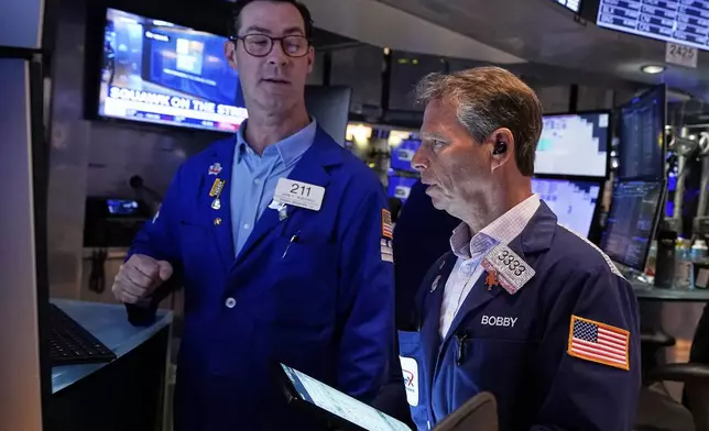 Specialist John McNierney. Left, and trader Robert Charmak work on the floor of the New York Stock Exchange, Wednesday, April 16, 2025. (AP Photo/Richard Drew)