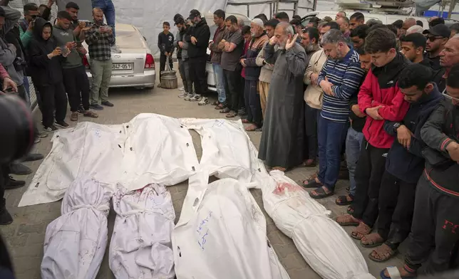 Palestinians pray over the bodie of Abdullah Habbash, along with the bodies of six brothers from the Abu Mahadi family, all members of a Palestinian charity organization linked to Hamas, who were killed earlier in an Israeli army strike on the car they were traveling in, during their funeral in Deir al-Balah, central Gaza Strip, Sunday, April 13, 2025. (AP Photo/Abdel Kareem Hana)"