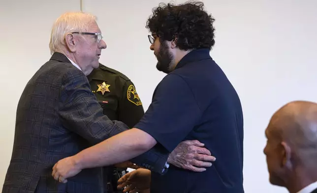 An Orange County Superior Court jury found Orange County Superior Judge Jeffrey Ferguson, left, guilty of second-degree murder in the 2023 shooting death of his wife Sheryl Ferguson, and after he embraced his son, Phillip Ferguson, before being led away in handcuffs Tuesday, April 22, 2025, in Santa Ana, Calif. (Mindy Schauer/The Orange County Register via AP, Pool)