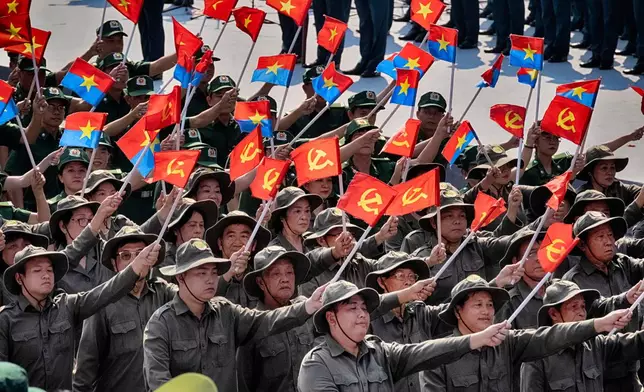 A Vietnamese military unit waves Vietnamese and hammer and sickle flags during a parade celebrating the 50th anniversary of the end of the Vietnam War on Wednesday, April 30, 2025, in Ho Chi Minh City, Vietnam. (AP Photo/Richard Vogel)