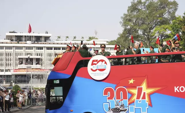 Vietnam War veterans on an open bus pass the Independence Palace during a parade to commemorate the 50th anniversary of the end of the Vietnam War in Ho Chi Minh City Wednesday, April 30, 2025. (AP Photo/Hau Dinh)