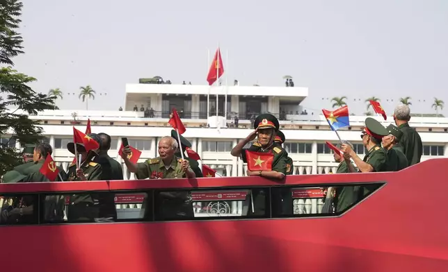 Vietnam War veterans on an open bus pass the Independence Palace during a parade to commemorate the 50th anniversary of the end of the Vietnam War in Ho Chi Minh City Wednesday, April 30, 2025. (AP Photo/Hau Dinh)