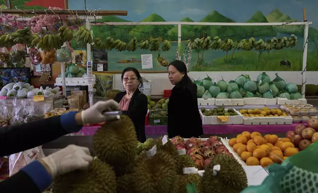 Two Vietnamese women shop for fruit at a market in the Little Saigon neighborhood of Westminster, Calif., Friday, April 25, 2025. (AP Photo/Jae C. Hong)
