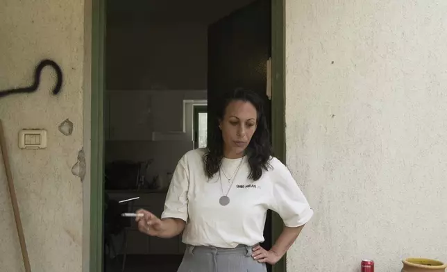 Lishay Miran Lavi, whose husband of Omri Miran is held captive by Hamas in the Gaza Strip, smokes at the family's home in Kibbutz Nahal Oz, southern Israel, Wednesday, April 9, 2025. (AP Photo/Maya Alleruzzo)