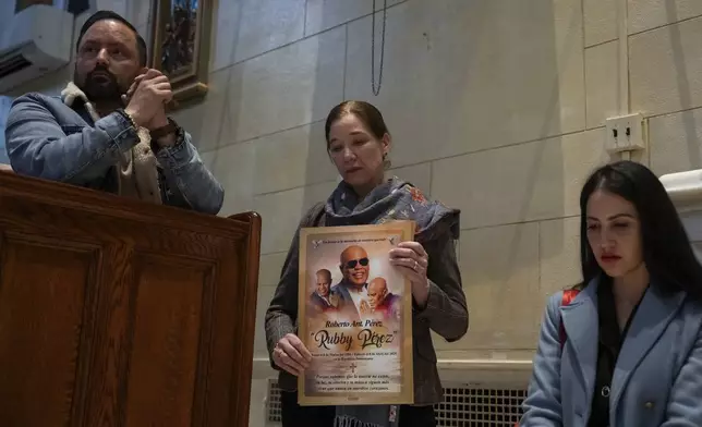 People attend a Mass, holding an image of Rubby Perez, for the victims of the Jet Set club roof collapse, at St. Elizabeth's Church, Wednesday, April 9, 2025 in New York. (AP Photo/Adam Gray)