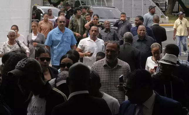 Mourners arrive to attend a memorial for Rubby Perez, the merengue singer who was performing at the Jet Set nightclub when its roof collapsed, killing more than 200 people, at the National Theater in Santo Domingo, Dominican Republic, Thursday, April 10, 2025. (AP Photo/Matias Delacroix)